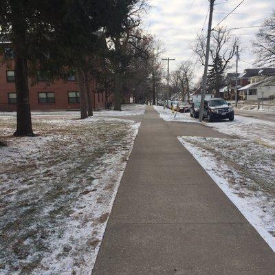 A snowy sidewalk by the quads at Knox College