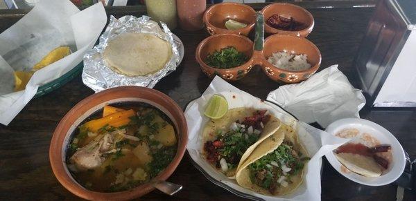 The entire meal chips/salsa, caldo de pollo, chorizo and tripa tacos, with condiments