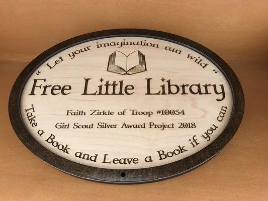 Custom oval plaque with laser carved made out of maple wood for the Girl Scout library post.