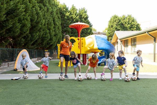 Coach Sarah showing the children how to control their soccer ball.