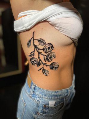 Skulls on a vine rib tattoo