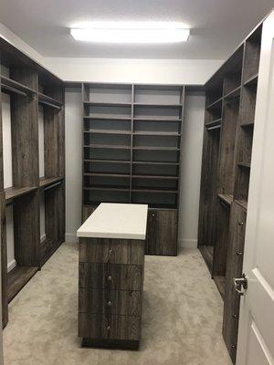 Master closet with island and stone tops.