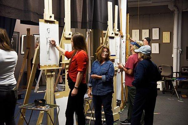 Director/Instructor Cyd Wicker giving student critique in life drawing class.