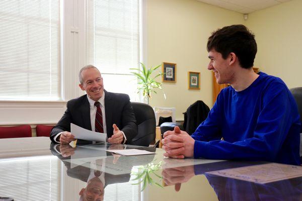 Headmaster Rene Menard congratulates a student.