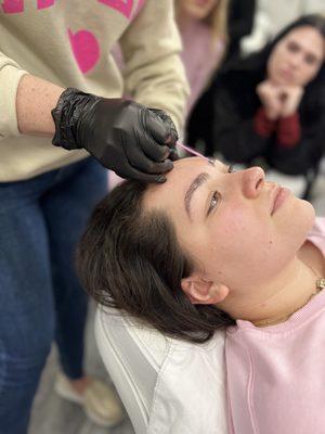 Teaching brow lamination to an eager group of future estheticians.