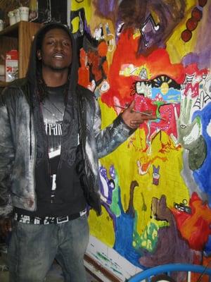 Youth artist Lowell Ligon with one of his art banners