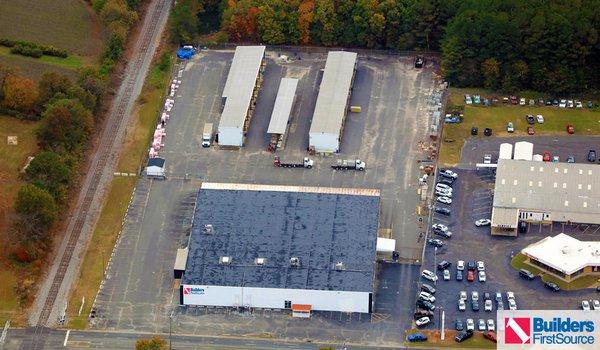 Building materials supplier Builders FirstSource's forklift is moving wood roof trusses.