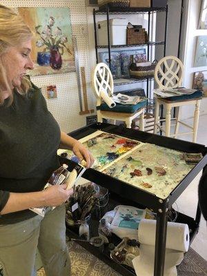 Lorrie shares tips on oil paint medium with a group.