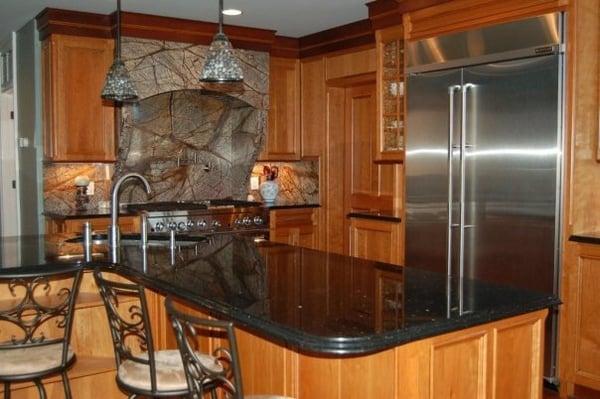 Black Galaxy countertops, and a custome range hood made out of Forrest Green marble.