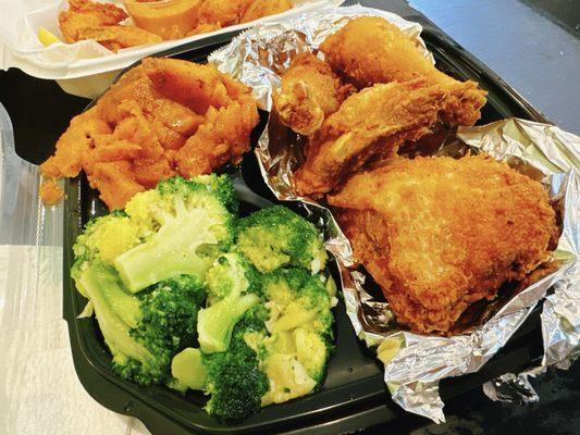 Fried chicken with sides of yam and broccoli.