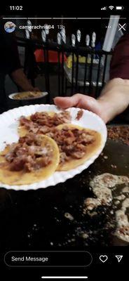 They prepare the tacos by picking up the meat with the tortilla. And the condiments are on the left side near the seating area.