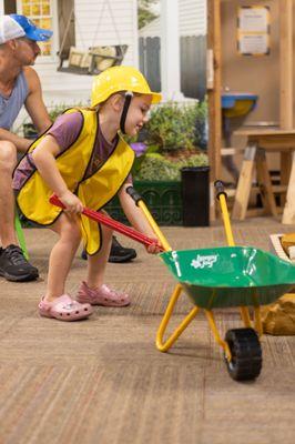 Child shovels' rocks in Itty Bitty Builders Exhibit.