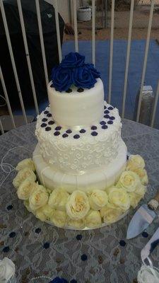 Red velvet cake with fondant decoration.  Fresh flowers surrounding cake.