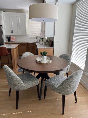 Hazelton Round Dining Table with custom fabric on Vera Dining Chairs.