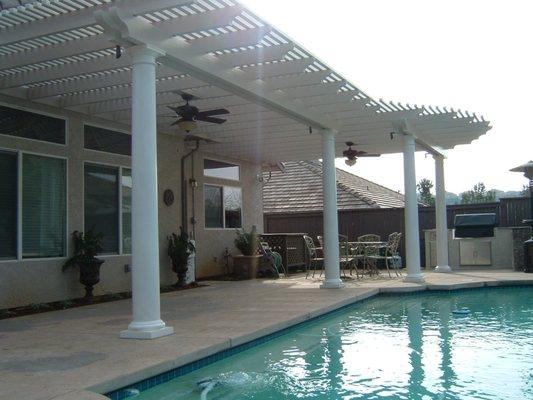 Pool side pergola with open lattice, columns and custom lighting.