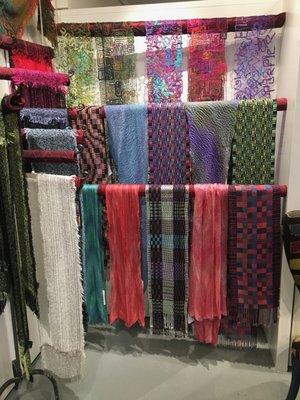 Assorted hand made scarves and wraps.