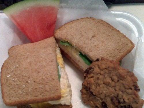 Chicken salad sandwich with cookie and watermelon