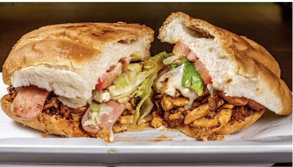 Our torta Cubana filled with chicken, chorizo, ham, sausage, bacon, egg, lettuce, tomato, and mayonnaise.