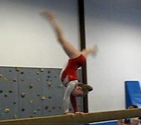 Balance beam with rock-climbing wall in background