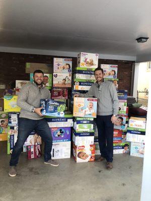 Our co-founders in front of the 10,000 diapers we raised for our 2018 holiday diaper drive.