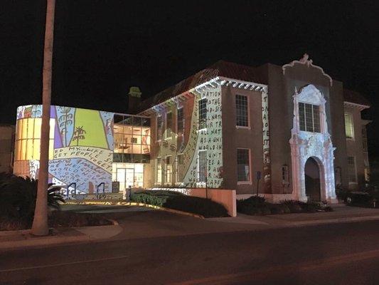 The image projected on the building is the art of Howard Finster for a downtown event sponsored by Public Eye Soar in 2016