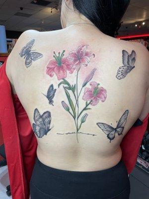 Color tattoo on back of butterflies and lily flowers