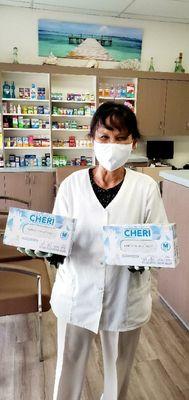 Pharmacy technician holding donated gloves.