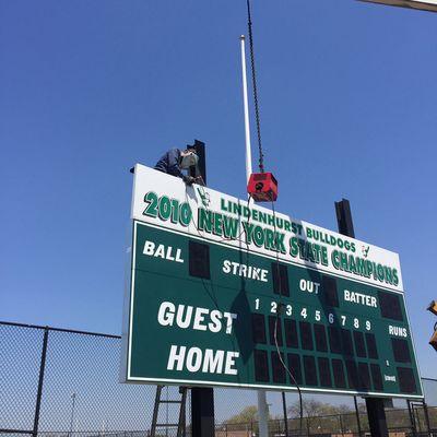 Steel work being done to finish a new outdoor baseball sign!