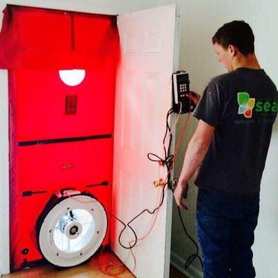 Service tech performing a blower door test as part of the energy assessment process