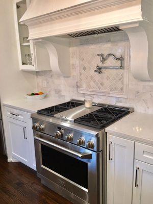 Details of marble back splash with decorative window and pot filler