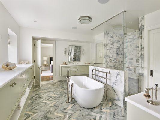 This expansive master bath has been beautifully renovated with marble tiling on the floor and in the walk-in, frameless shower enclosure.