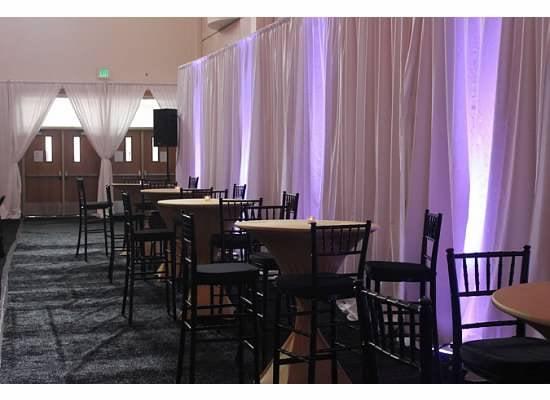 High Boy Tables with spandex linens, pipe and drape, up-lights, and black astro turf