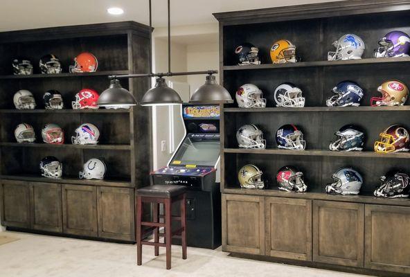 Custom NFL helmet display cabinetry in finished basement.