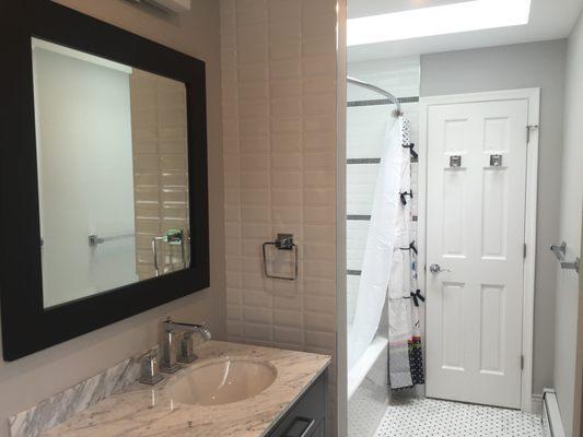 Doubling the square footage of bathroom by claiming a portion of cedar closet and bringing light through skylight opening in the ceiling