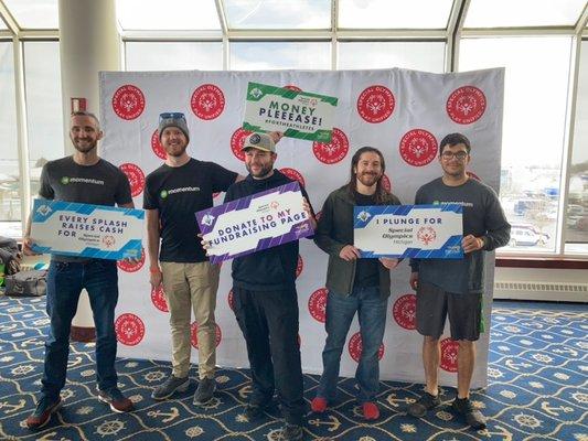 Momentum team members, Andrew, Bryan, Adam, Cody, and Jimi holding fundraising signs supporting Special Olympics Michigan