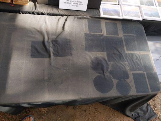 Here is an image showing the dust that accumulated on my black tablecloth during a day of vending with the imprints of my product.