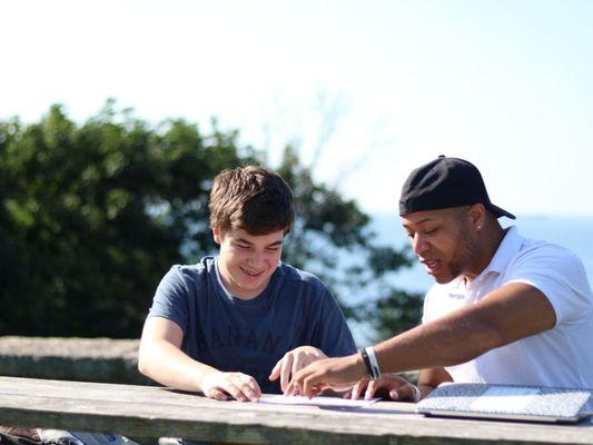 Student and teacher working on reading skills in a one-to-one tutorial.