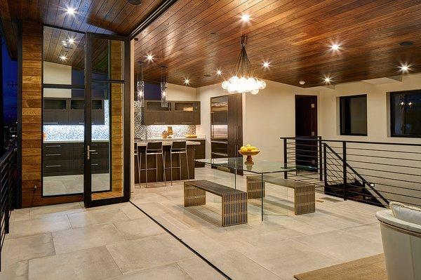 The stone flooring and wood ceiling continue from inside to out in order to connect the home to the outdoors.