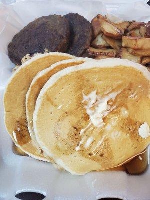 Pancakes and sausage and home fried potatoes and orange juice