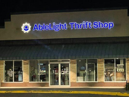 Exterior of AbleLight Thrift Shop at night.