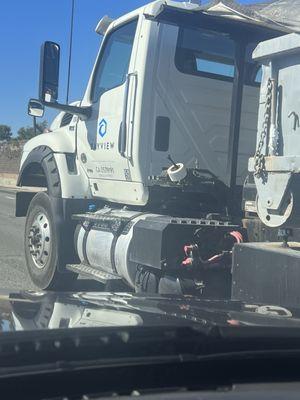 Load not properly covered and spilling debris into traffic.