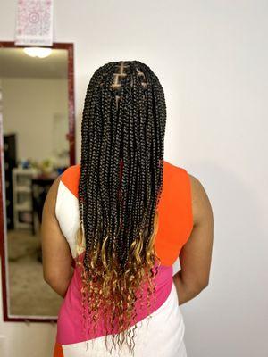 Medium knotless braids with wavy ends and a touch of color.