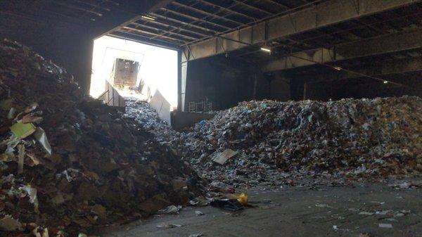 Tipper offloading a container of residential recycling