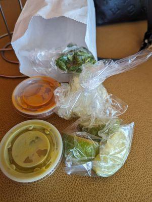 To-go sides of cilantro, onion, limes, red and green salsa.