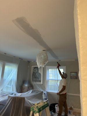 Drying a crack in the ceiling after patching it up and before painting it.