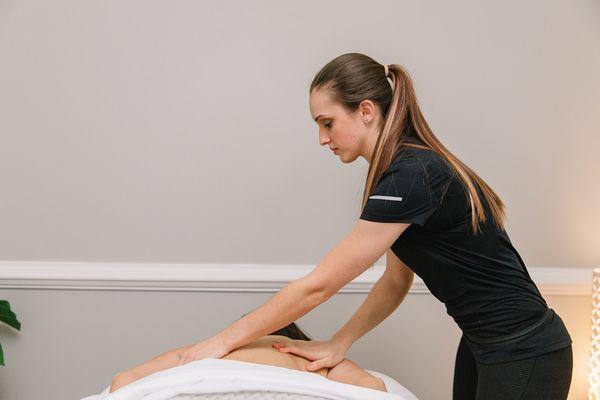 Gabrielle giving a therapeutic massage, which can help with muscle pain, joint pain, headaches, stress/anxiety and can improve sleep quality