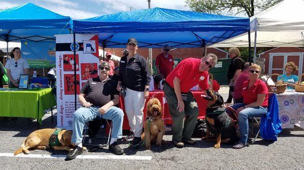 Fidos Therapy Dogs and their handlers are at a community event, telling attendees about the programs that we offer.