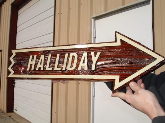 A hand-painted custom shaped sandblasted sign.