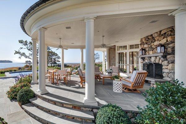 Waterfront porch with fireplace and flagstone terrace by Davenport Contracting Inc.