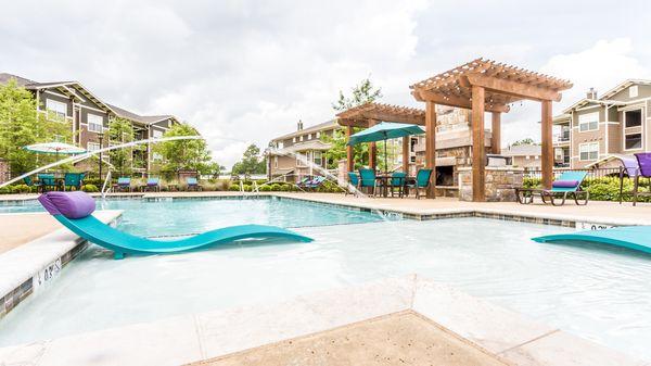 Sparkling resort style pool with fireplace and gas grills